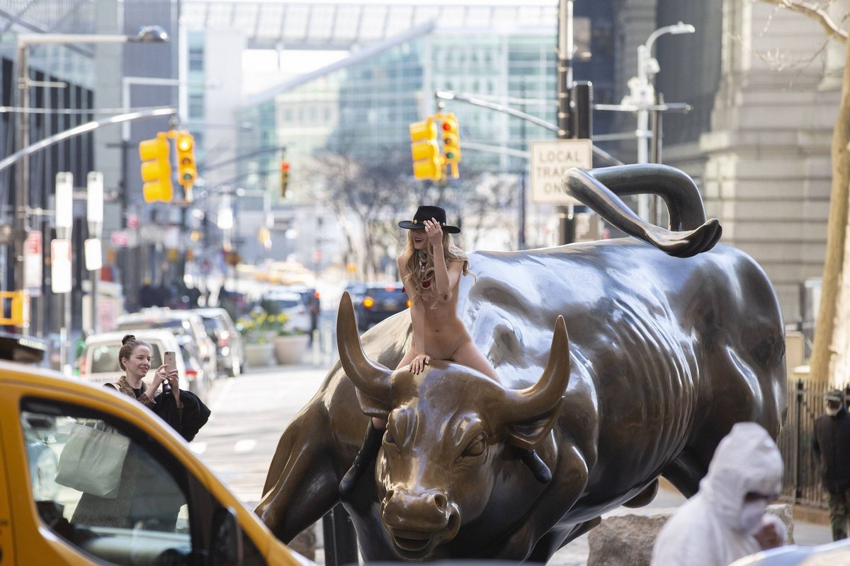 Голая девушка оседлала статую быка в Нью-Йорке...